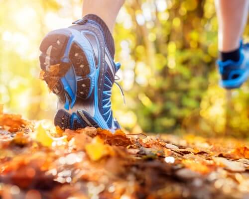 Sneakers of a person trail running outdoors for cardio fitness and endurance training