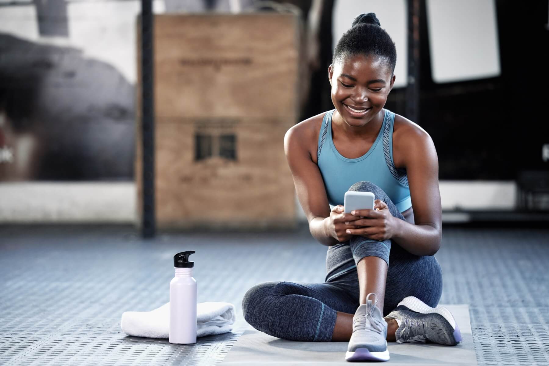 Woman using smartphone to contact fitness support team